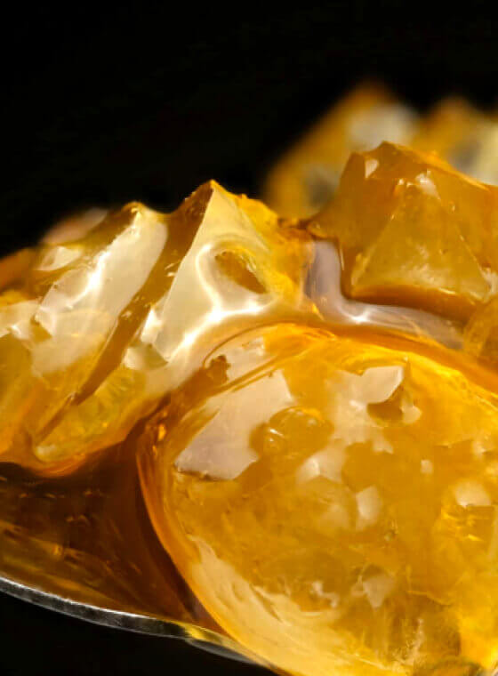 A close up shot of amber colored weed extract full of flavorful terpenes and potent cannabinoids that can be dabbed in a dab rig.